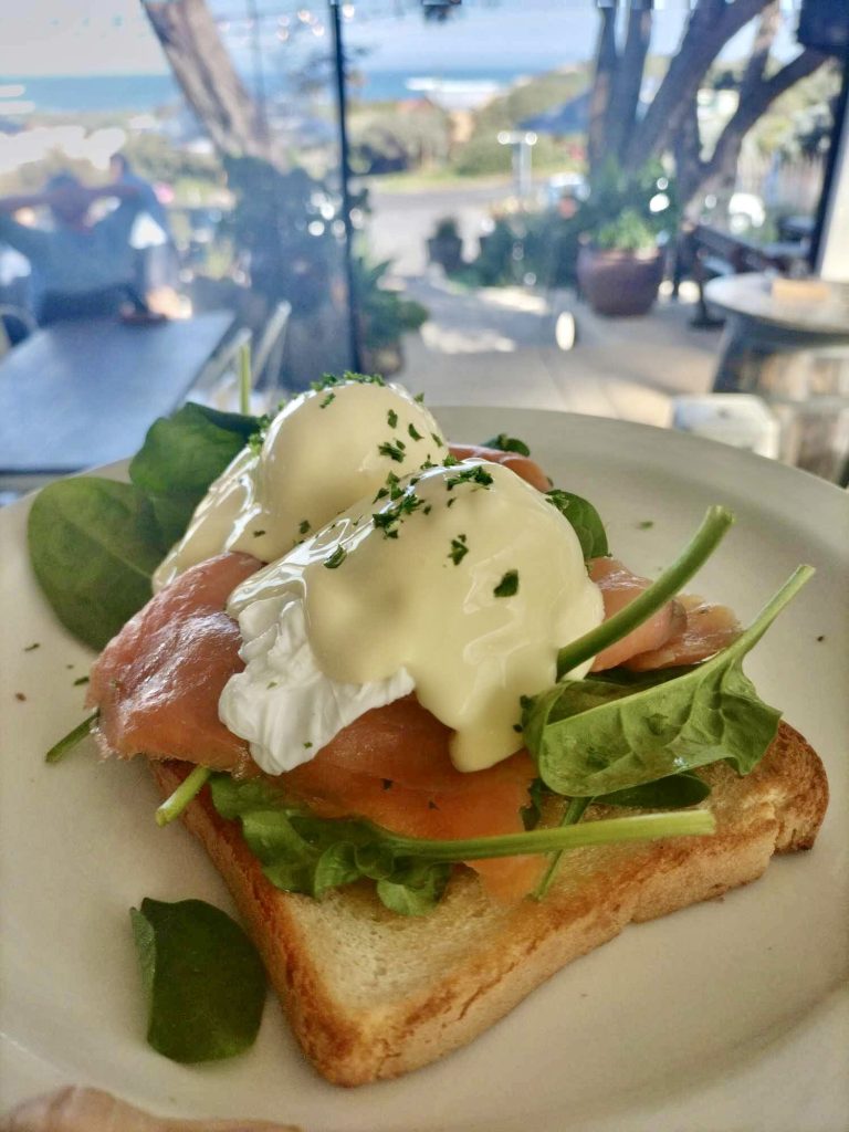 poached eggs Benedict with ocean views in background
