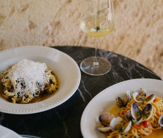 plates of pasta and glass of white wine