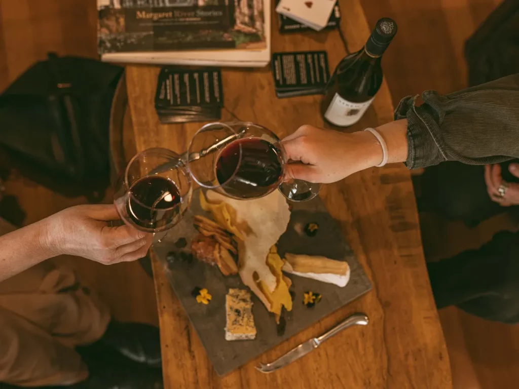 Red wine glasses cheers over a cheese board